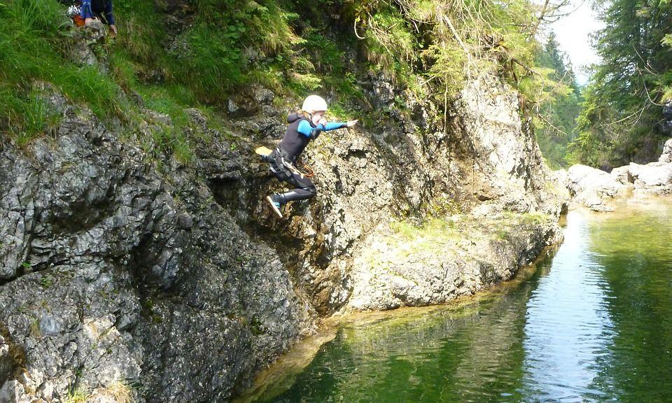 Canyoning-Schlucht mit grünem Wasser und Menschen am Fels
