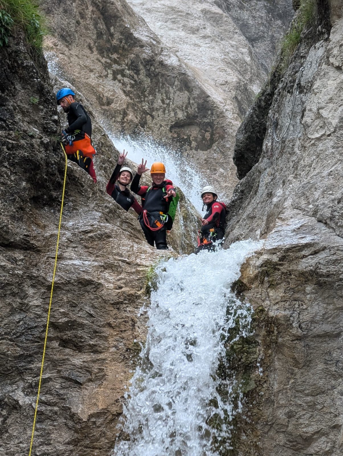 Gruppe jubelt unter dem Wasserfall am Fischbach